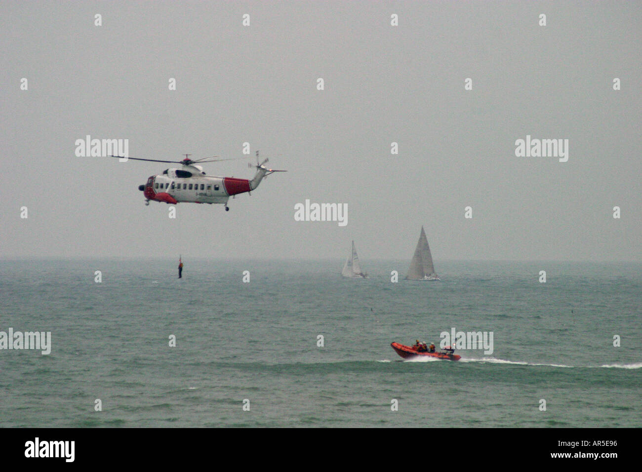 Helicóptero de rescate en el mar de aire con malacate y bote salvavidas Foto de stock