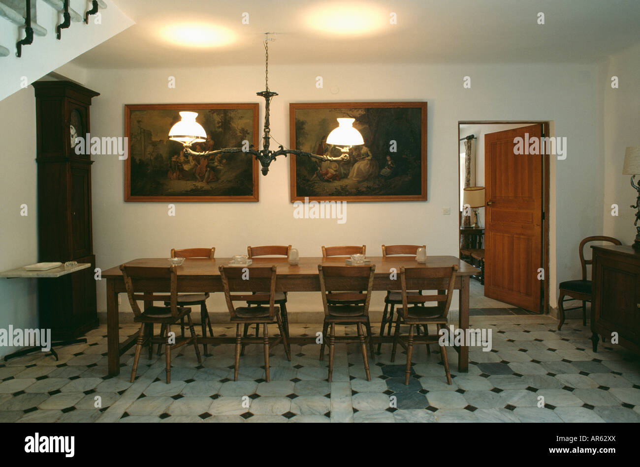 Iluminación de estilo victoriano de madera rectangulares encima de la mesa y las sillas en setenta Francés comedor con baldosas gris Foto de stock