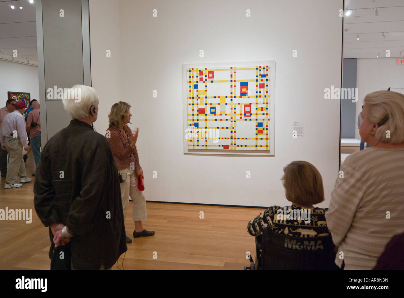 Guía y espectadores delante de la pintura de Mondrian, Broadway Boogie Woogie, el Museo de Arte Moderno de Nueva York Foto de stock