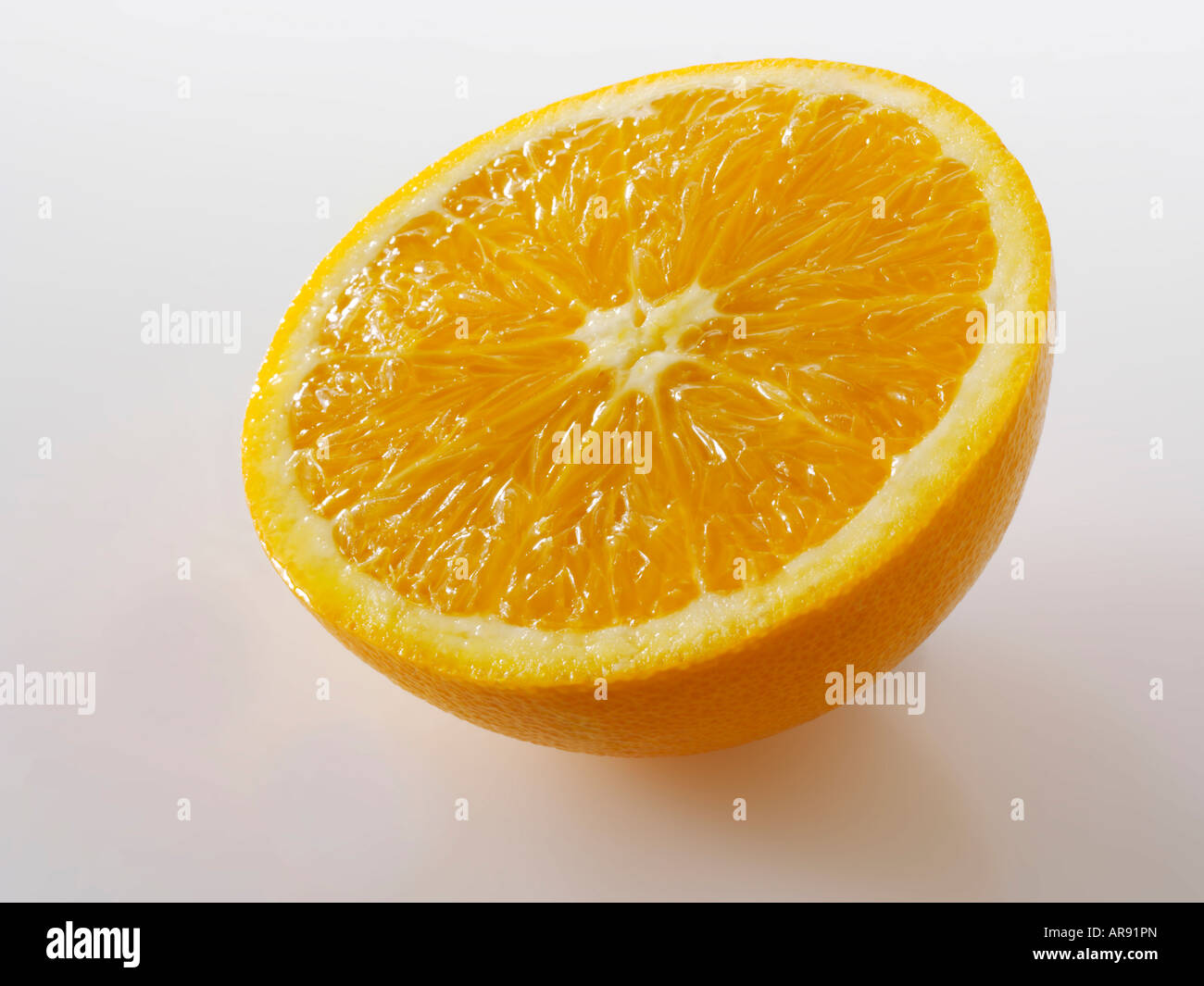 La mitad de una rodaja de naranja sobre un fondo blanco como un recorte Foto de stock
