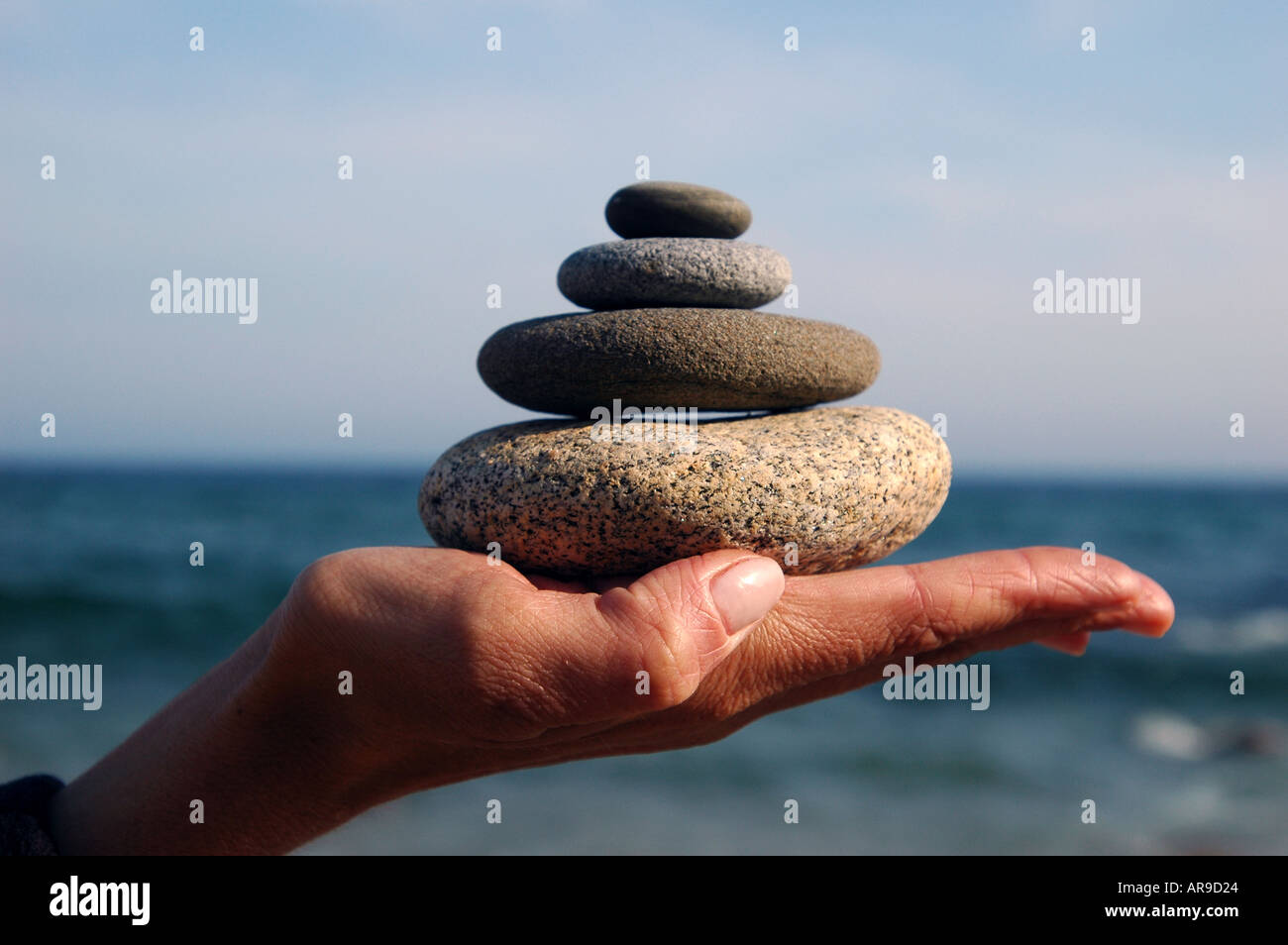 Relajarse yoga Mano con montón de rocas y pulcritud de diseño Foto de stock