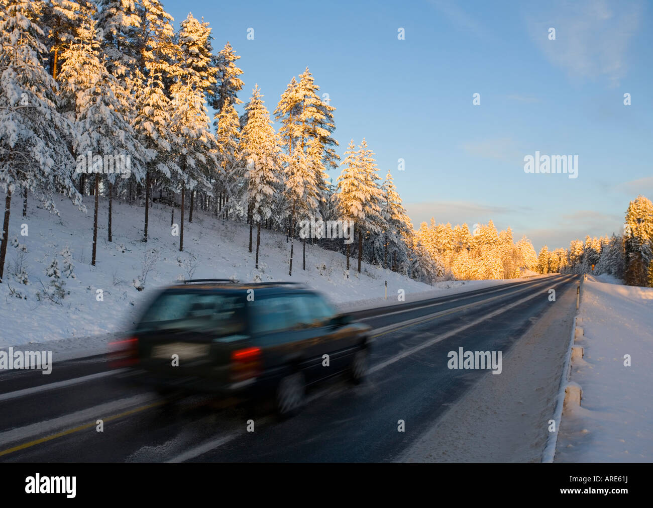 Coche de conducción en autopista en la luz del atardecer en invierno , Finlandia Foto de stock