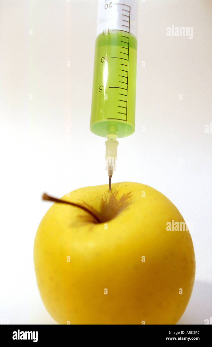 Fotografía simbólica: una manzana con la inyección. Alimento envenenado, alimentos modificados genéticamente, fruto envenenado. Foto de stock