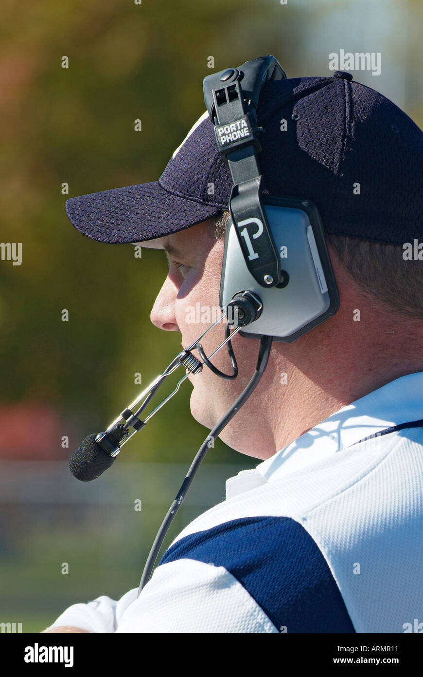 Entrenador de Fútbol americano a nivel High School comunicarse con otros entrenadores por medio del uso de auriculares inalámbricos Foto de stock
