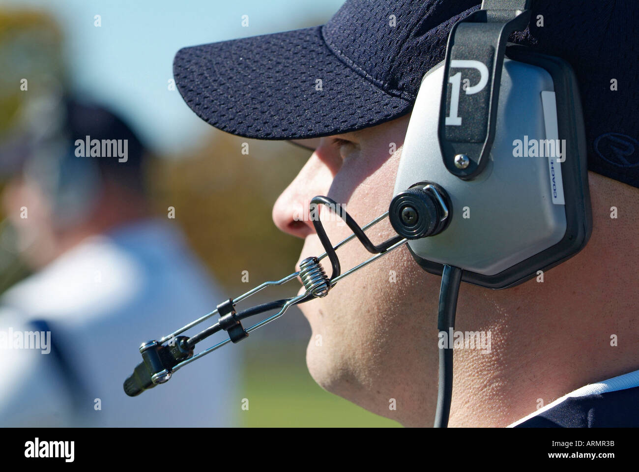 Entrenador de Fútbol americano a nivel High School comunicarse con otros entrenadores por medio del uso de auriculares inalámbricos Foto de stock