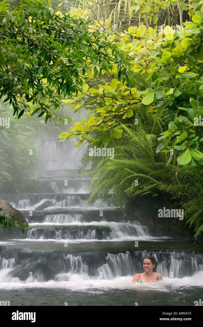 Un visitante disfruta de uno de los arroyos que caliente fluye a través de Tabacón Hot Spring Resort and Spa Costa Rica Foto de stock