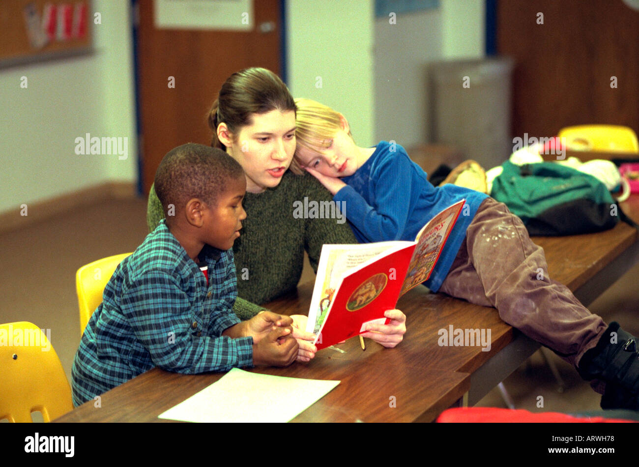 Maestros y alumnos libro de lectura en el programa después de la escuela en edades comprendidas entre 6 y 23. St Paul Minnesota, EE.UU. Foto de stock