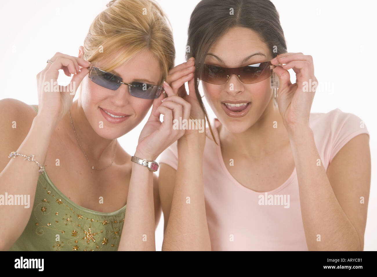 Las mujeres poniendo en gafas de sol Foto de stock