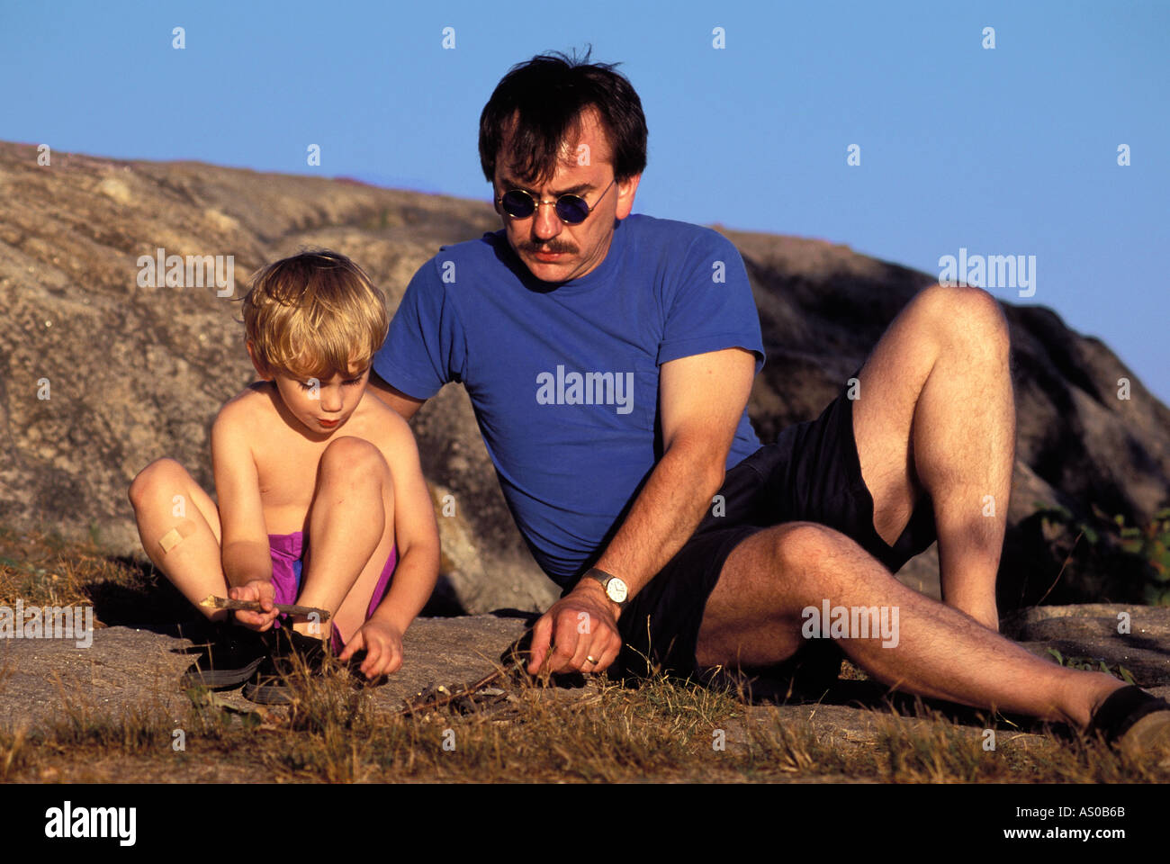 Padre e hijo, tocando en roca en vacaciones, Connecticut, EE.UU. Foto de stock