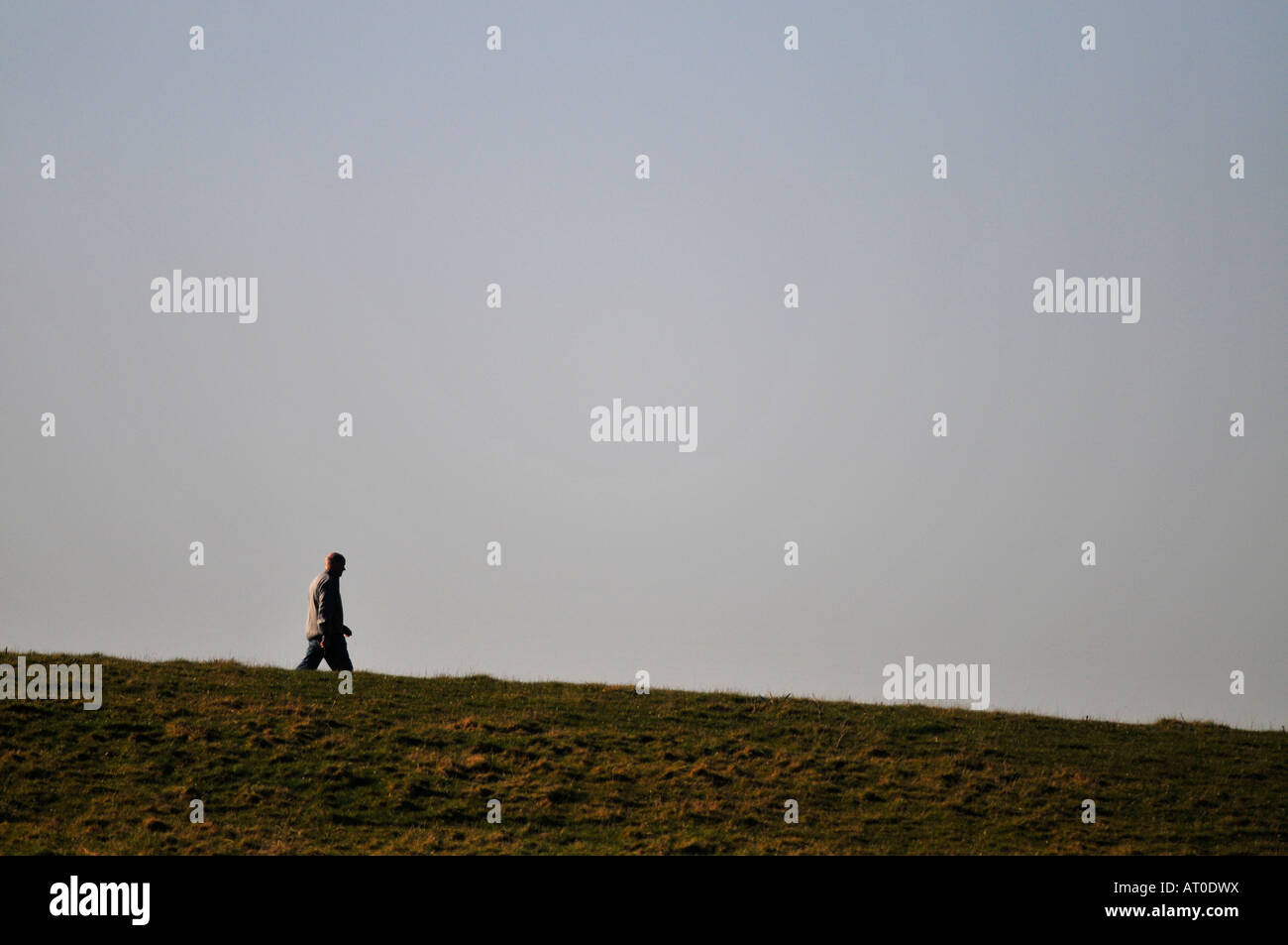 Caminante solitario en la cima de una colina Foto de stock