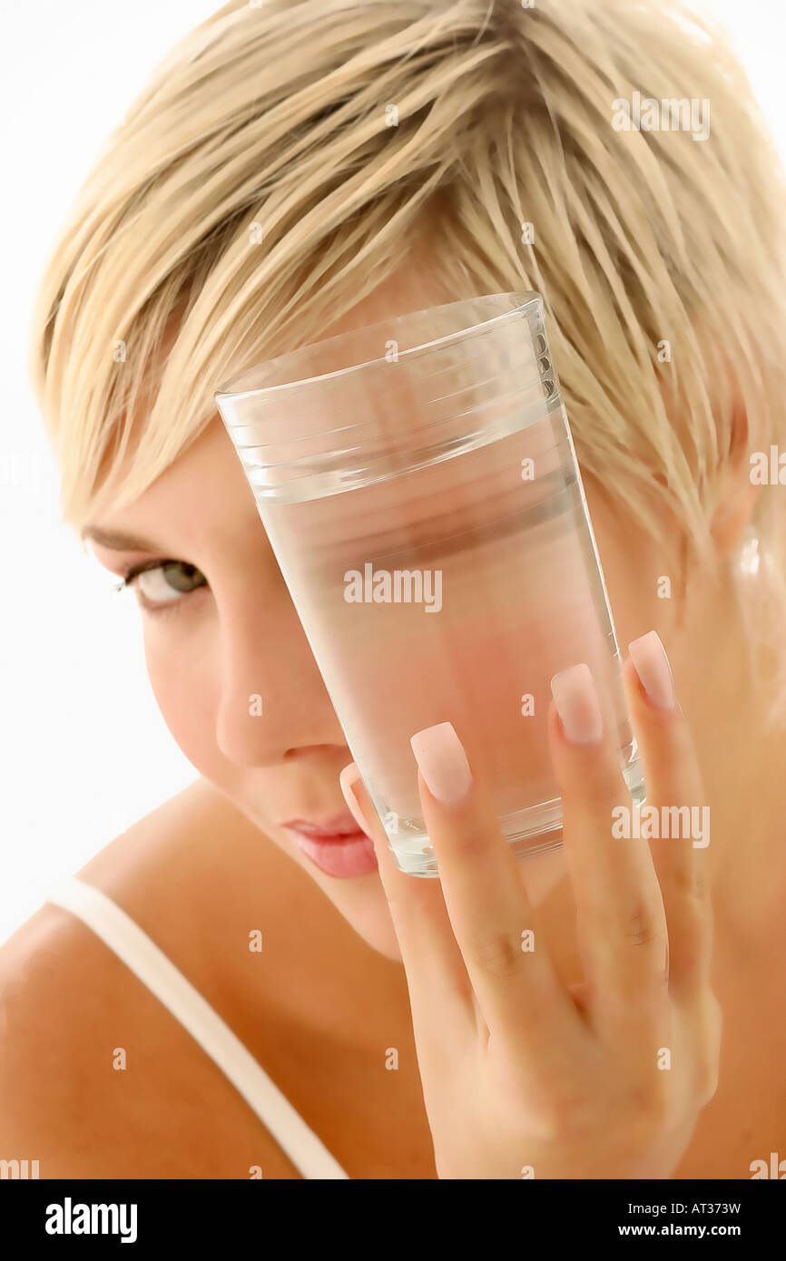 Una mujer mirando a través de un vaso de agua Fotografía de stock - Alamy