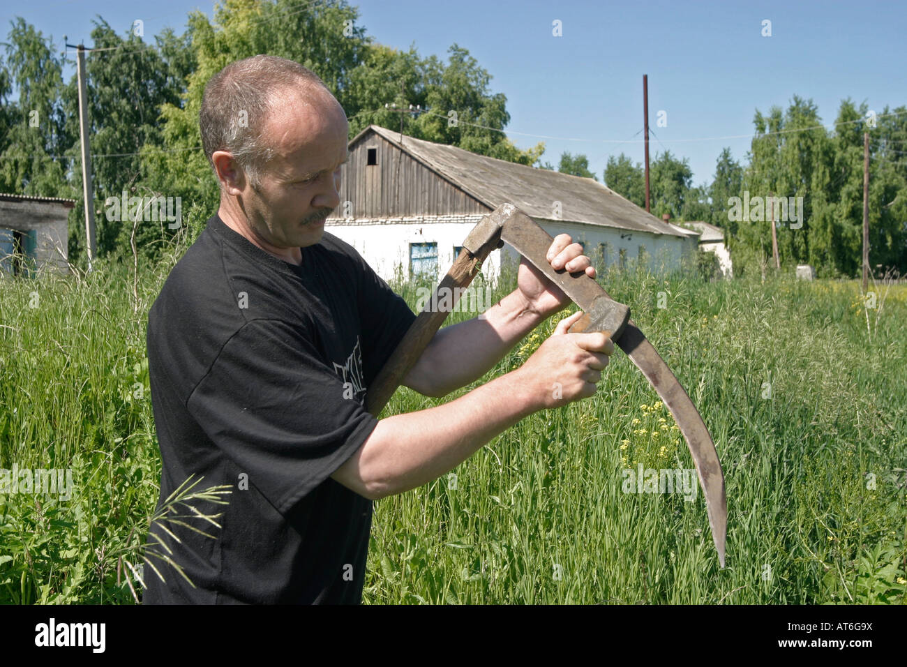 El hombre de la guadaña de afilado Bashkortosatan blagovar región República de Federación de Rusia Foto de stock