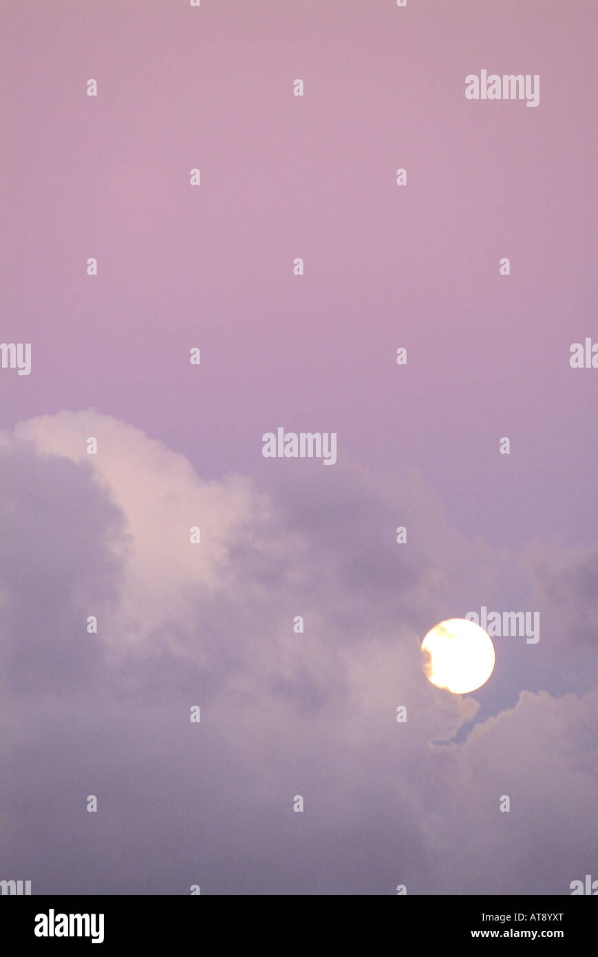 La luz de la luna llena en un cielo con lavanda hinchadas nubes blandas Foto de stock