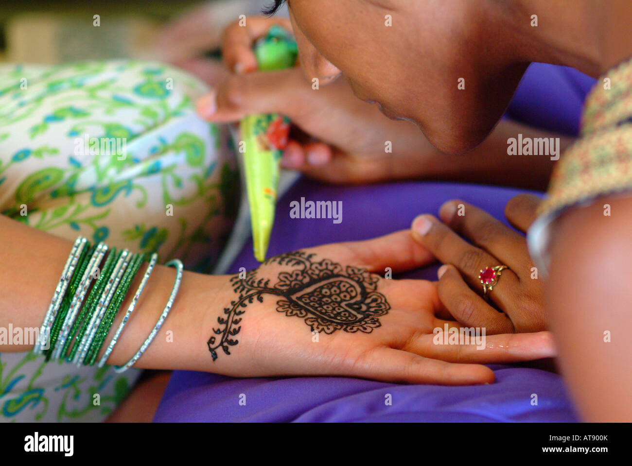 La mujer que recibe un diseño de henna mendhi en el interior de la palma de su mano en preparación para su ceremonia de boda hindi Foto de stock