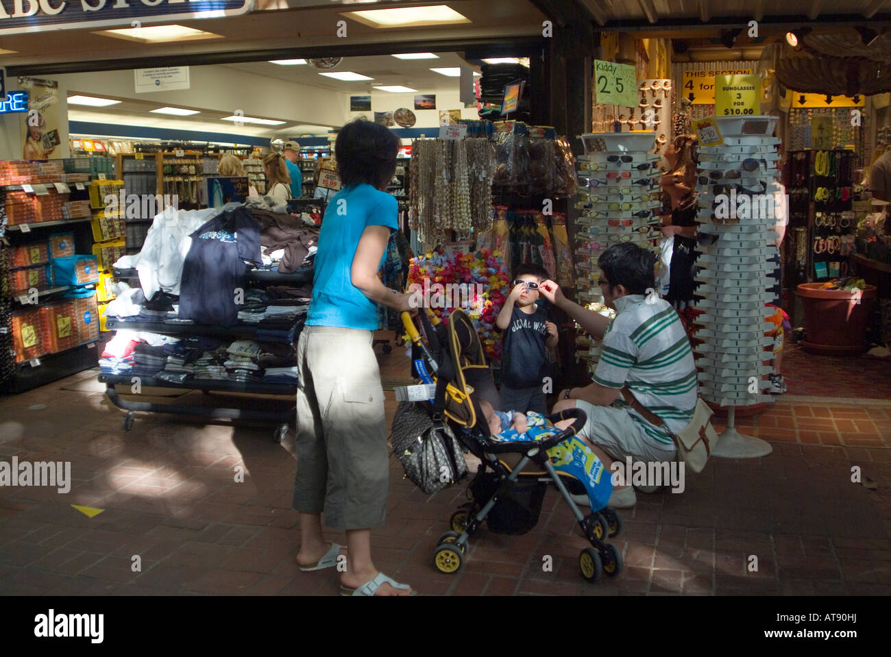 Los turistas de pie en frente de las tiendas en el mercado internacional en Waikiki. Foto de stock