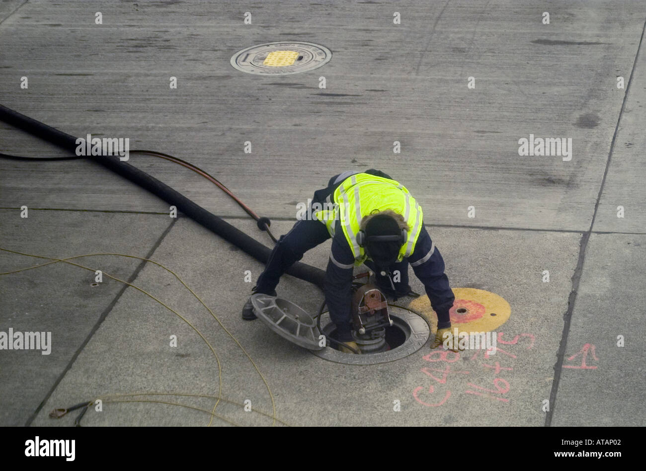 Conectar la manguera de combustible de trabajador de tierra en un aeropuerto Foto de stock