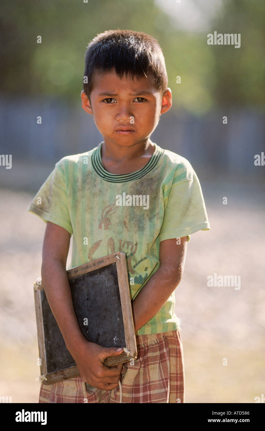 Libro joven llevando a la escuela en el bosque remoto pueblo en el sur de Laos Foto de stock