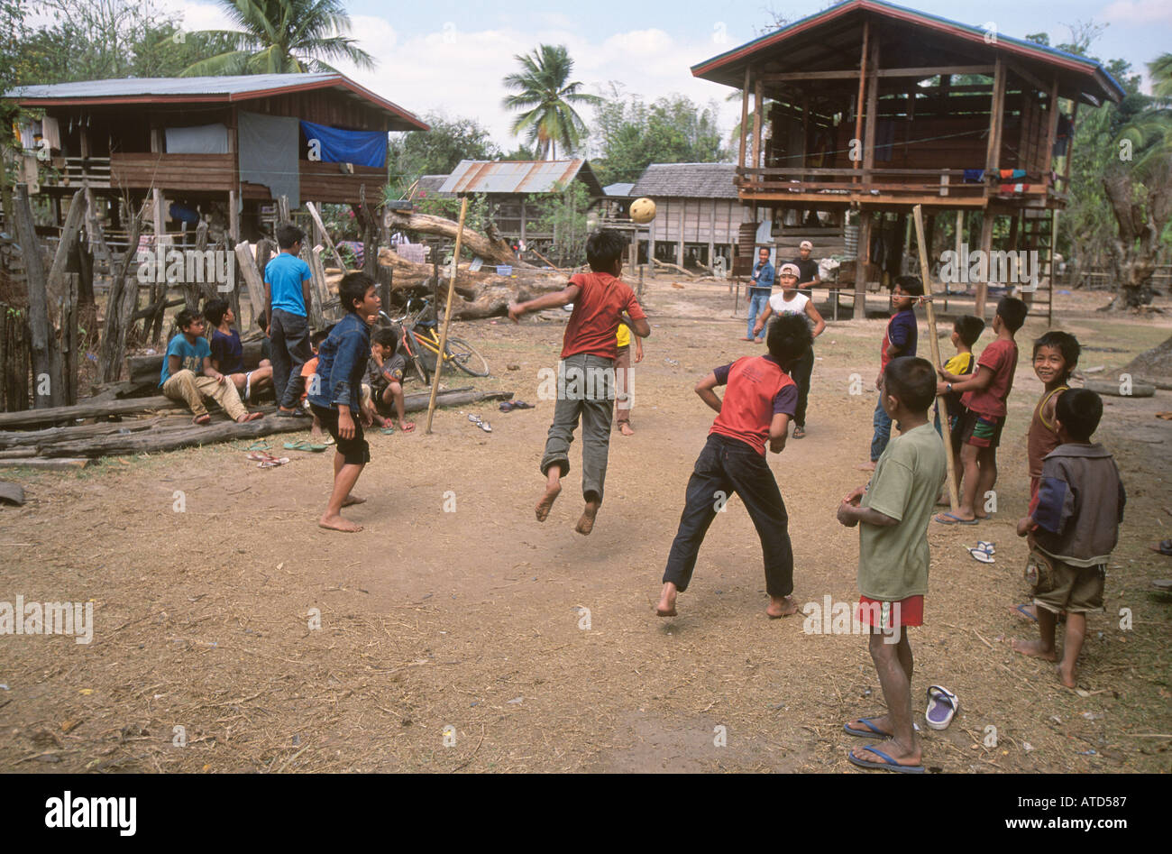 Niños jugando a pie shuttle en bosque remoto pueblo en el sur de Laos Foto de stock