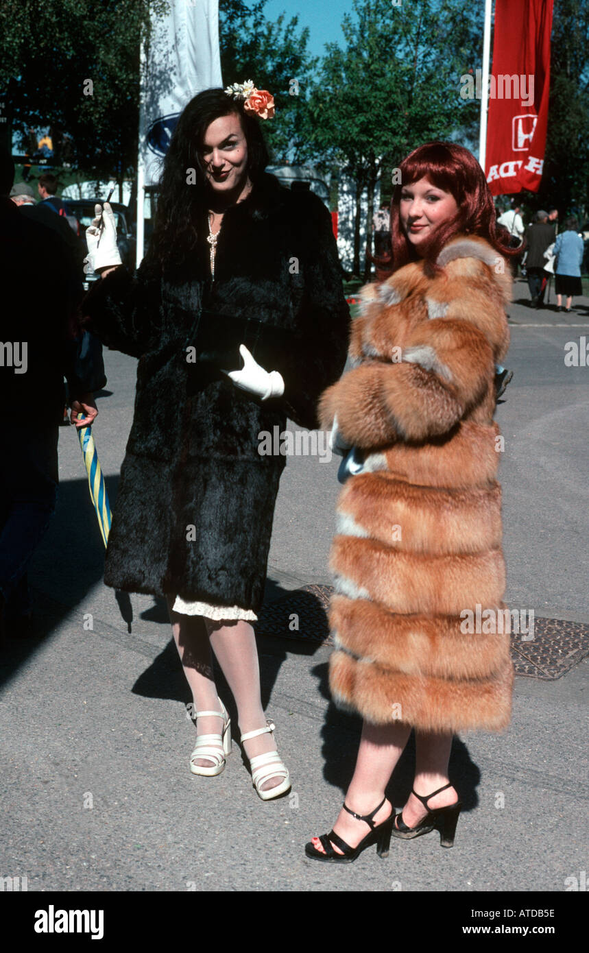 Dos mujeres en 1940 vestido de época, de estilo con falsos abrigos de piel posan para la cámara en el Goodwood revival reunión de carreras Foto de stock