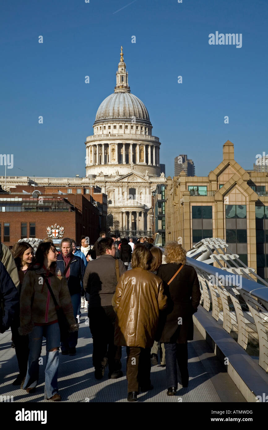 Multitudes de personas que cruzan Millenium Bridge hacia St Pauls Londres Inglaterra Foto de stock