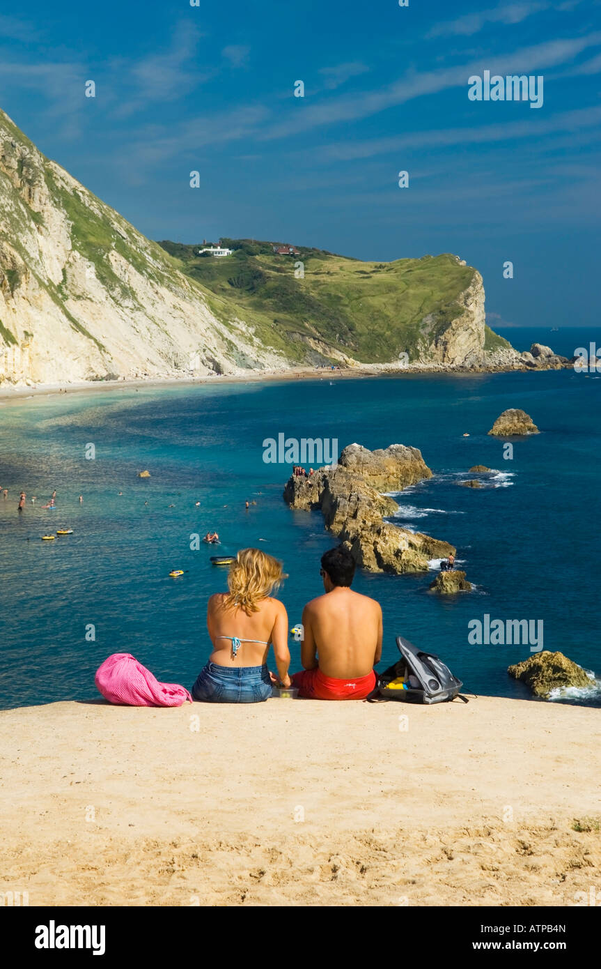 Reino Unido Inglaterra Dorset St Oswald's Bay pareja sentada en el borde del acantilado Foto de stock