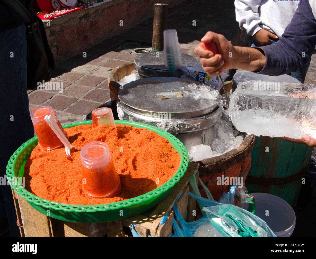 México Guanajuato Mano de macho proveedor de helados de la calle cincel bocas de bloque de hielo en el dulce pimienta condimento tradicional Foto de stock