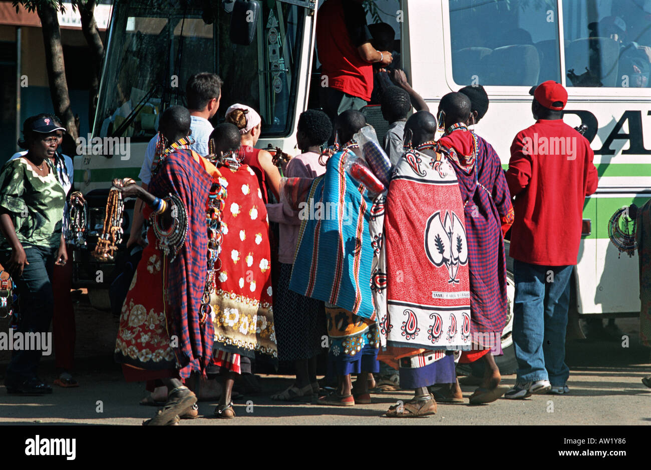 Mujeres masai de Kenya que venden recuerdos que rodean la puerta frontal de un autobús que transportaba a la gente a través de la frontera Namanga Tanzania Foto de stock