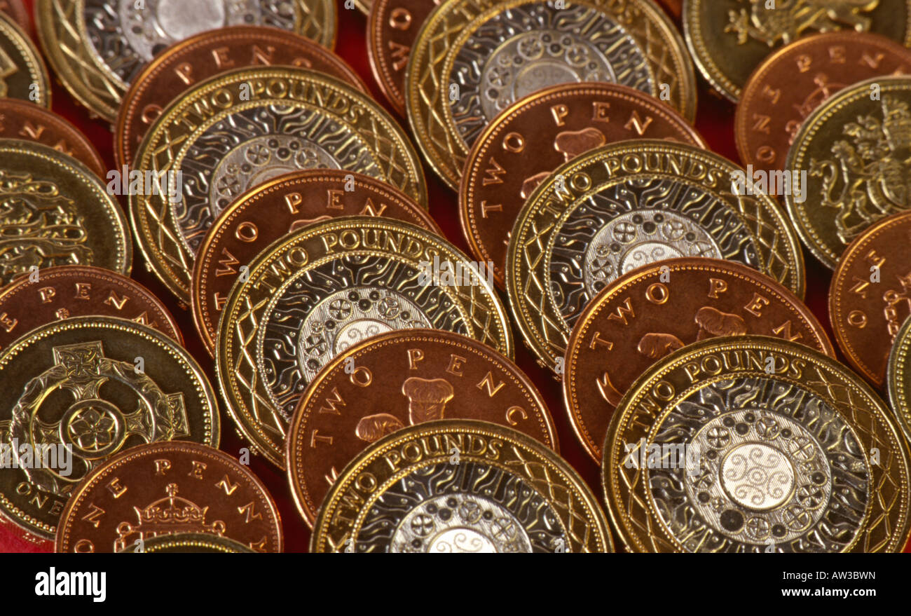 Dos libras y dos peniques de monedas con una libra y 1 peniques monedas en líneas diagonales Foto de stock