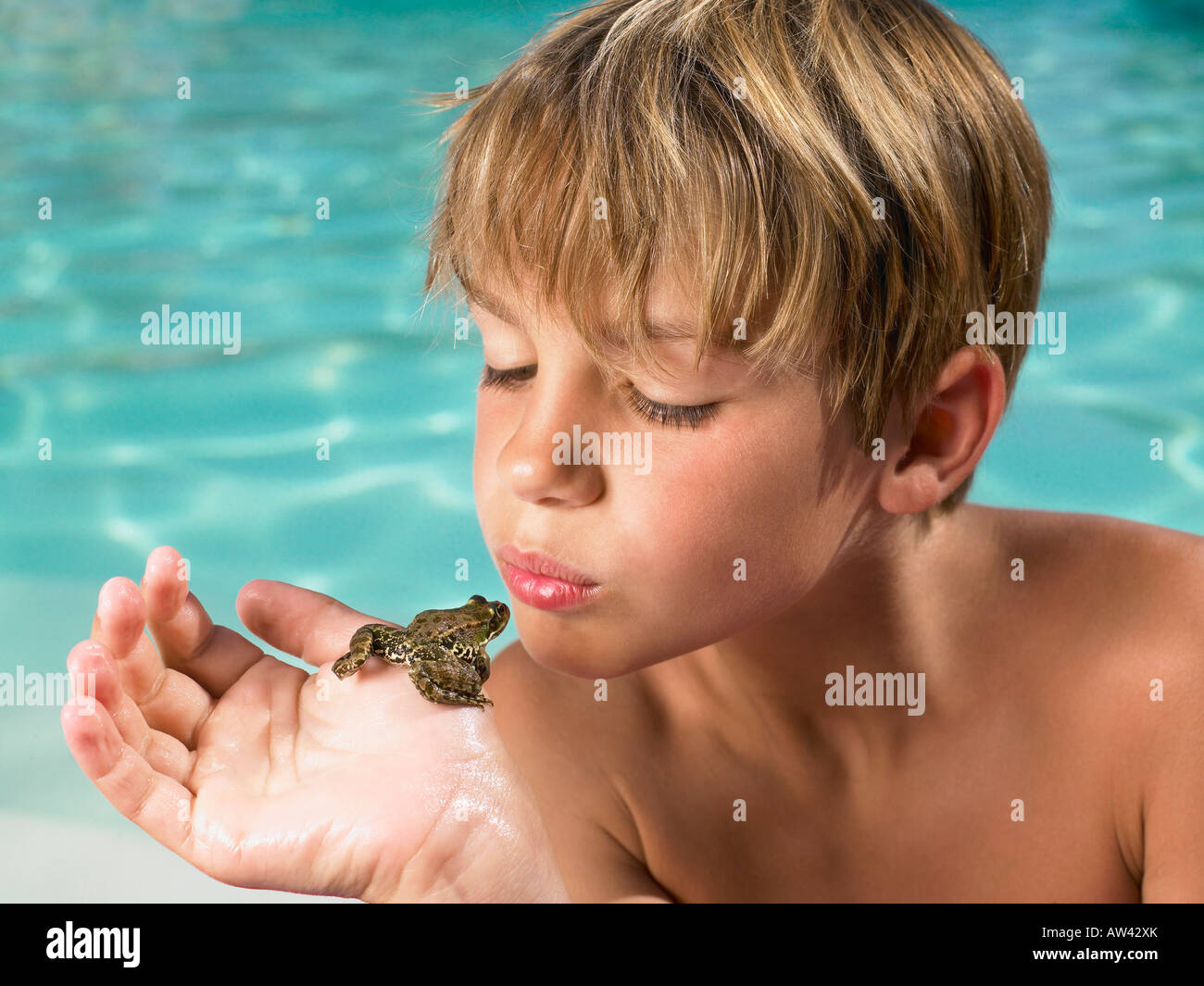 Niño sosteniendo una rana en su mano. Foto de stock