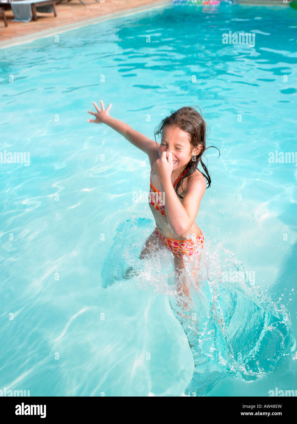 Chica saltando en la piscina. Foto de stock