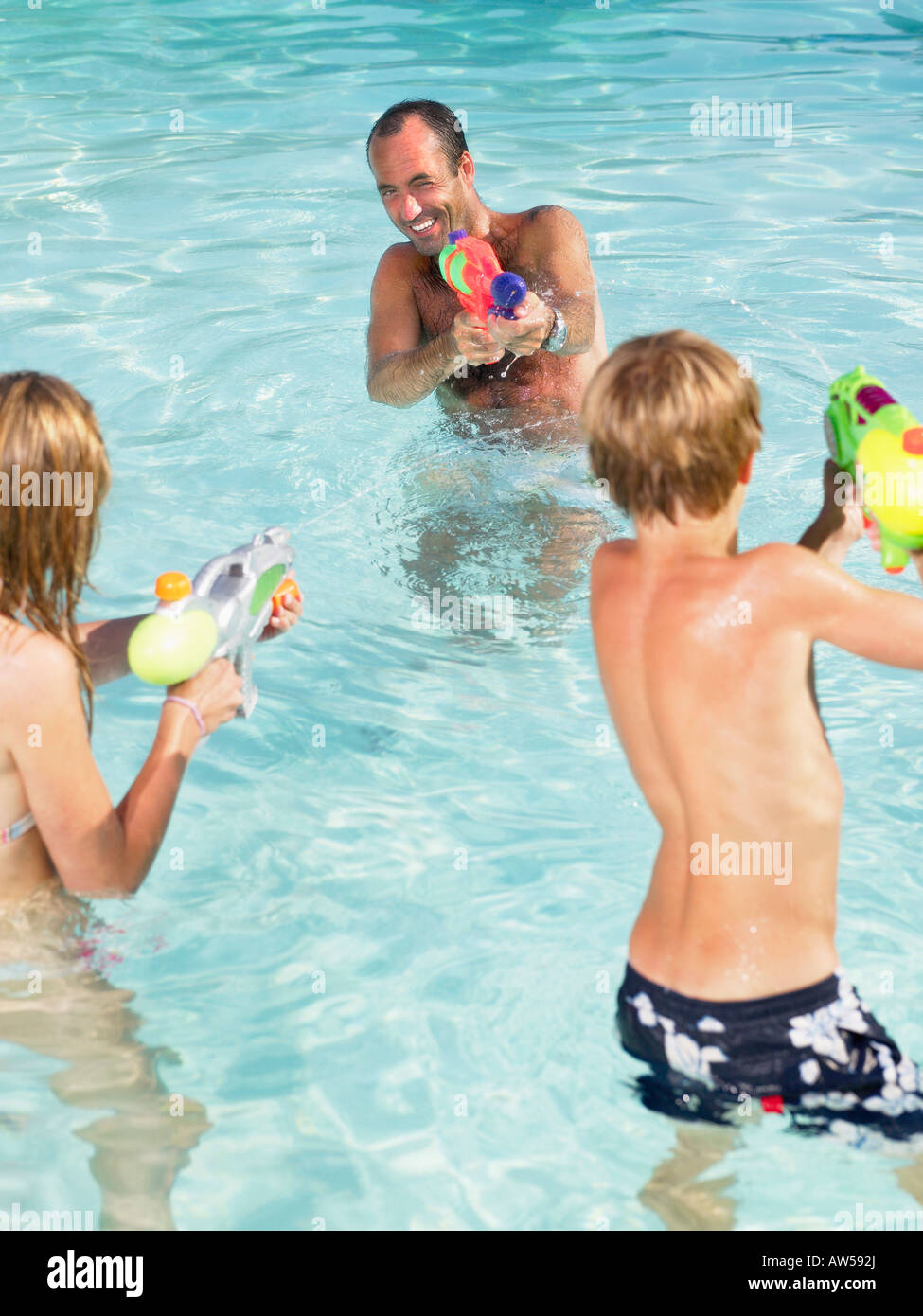 Adultos y niños jugando con pistolas de agua. Foto de stock