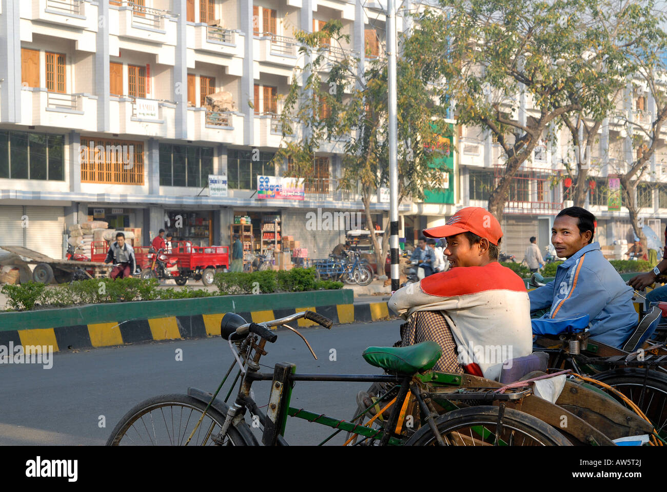 Los conductores de rickshaw están a la espera de los clientes en una de las calles principales de Myitkyina Foto de stock