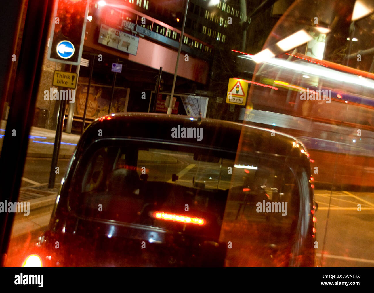 Un taxi de Londres y un autobús londinense desde el interior de un autobús en movimiento, streetscene Foto de stock