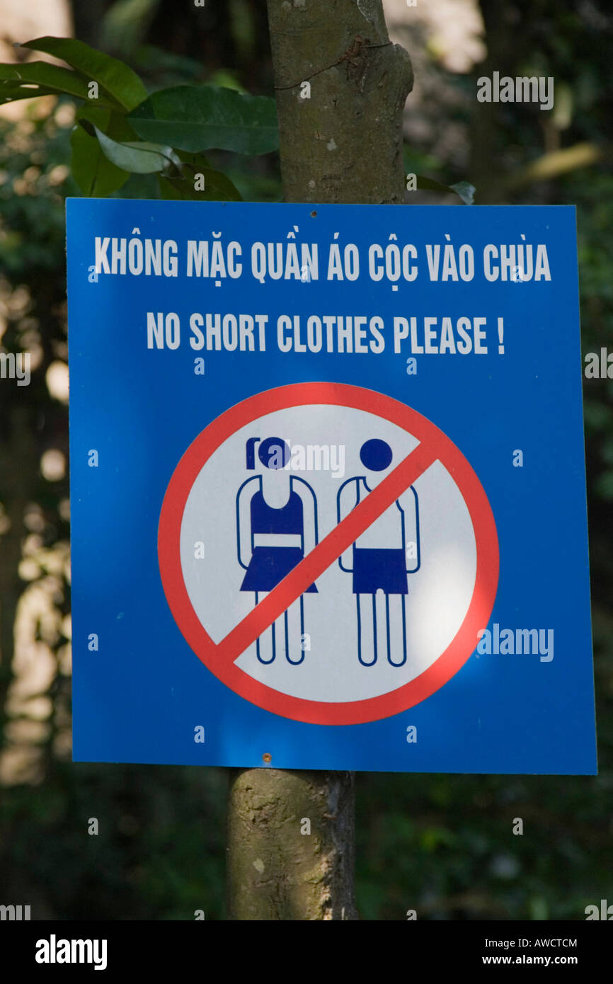 Señal de advertencia prohibiendo el uso de camisas de manga corta y pantalones cortos/faldas en un lugar santo en Mt. Huong Tich, Northern Vietna Foto de stock