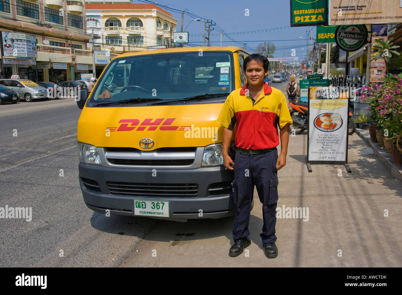 Servicio de mensajería DHL conductor de pie delante de su camioneta, Pattaya, Tailandia, el sudeste de Asia Foto de stock