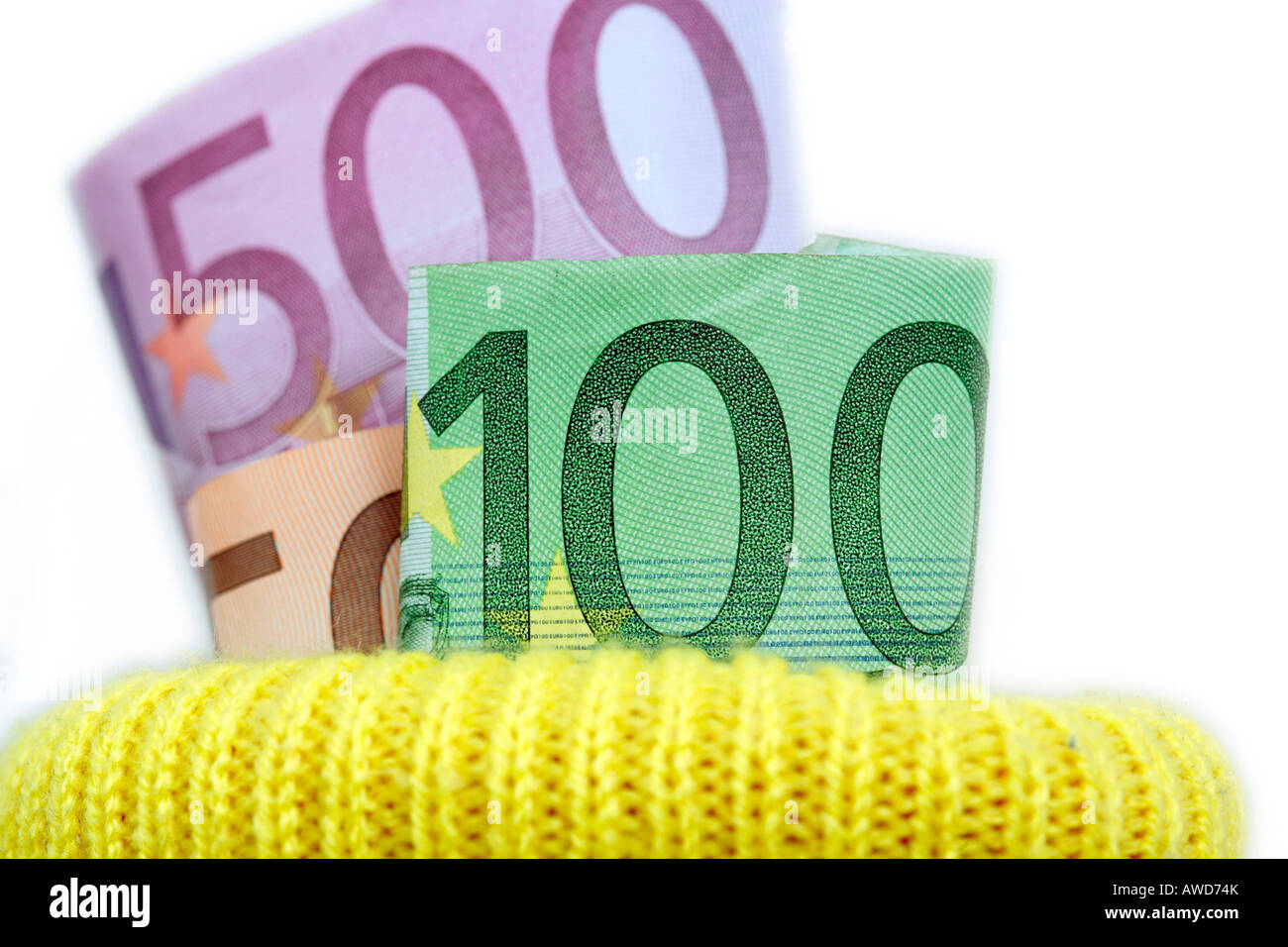 Ahorro de dinero - billetes de banco euro puestos en un depósito de calcetín amarillo Foto de stock