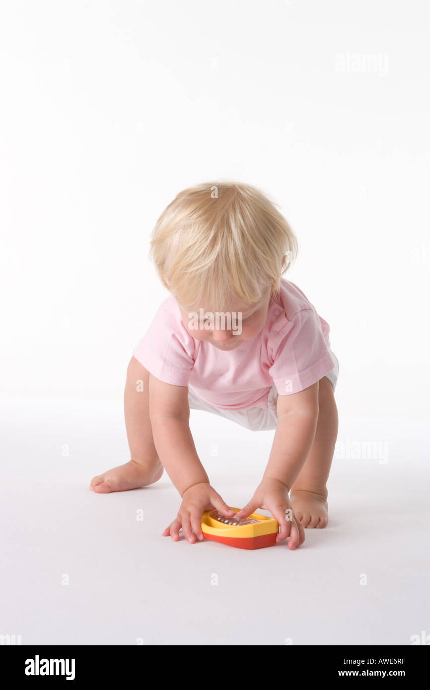 Niña recogiendo un juguete Fotografía de stock - Alamy