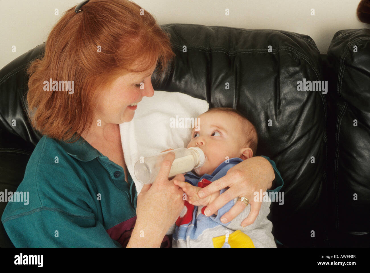 La alimentación de la madre lactante, bebé, salud, atención infantil, la crianza, la botella de leche, ojos grandes, lindo Ohio, EE.UU. Foto de stock