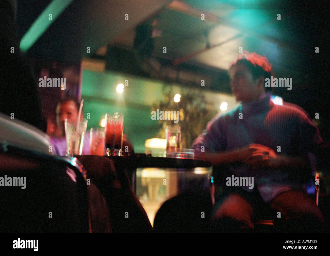 Joven sentado en el bar, segunda persona en el fondo, vista de ángulo bajo  Fotografía de stock - Alamy