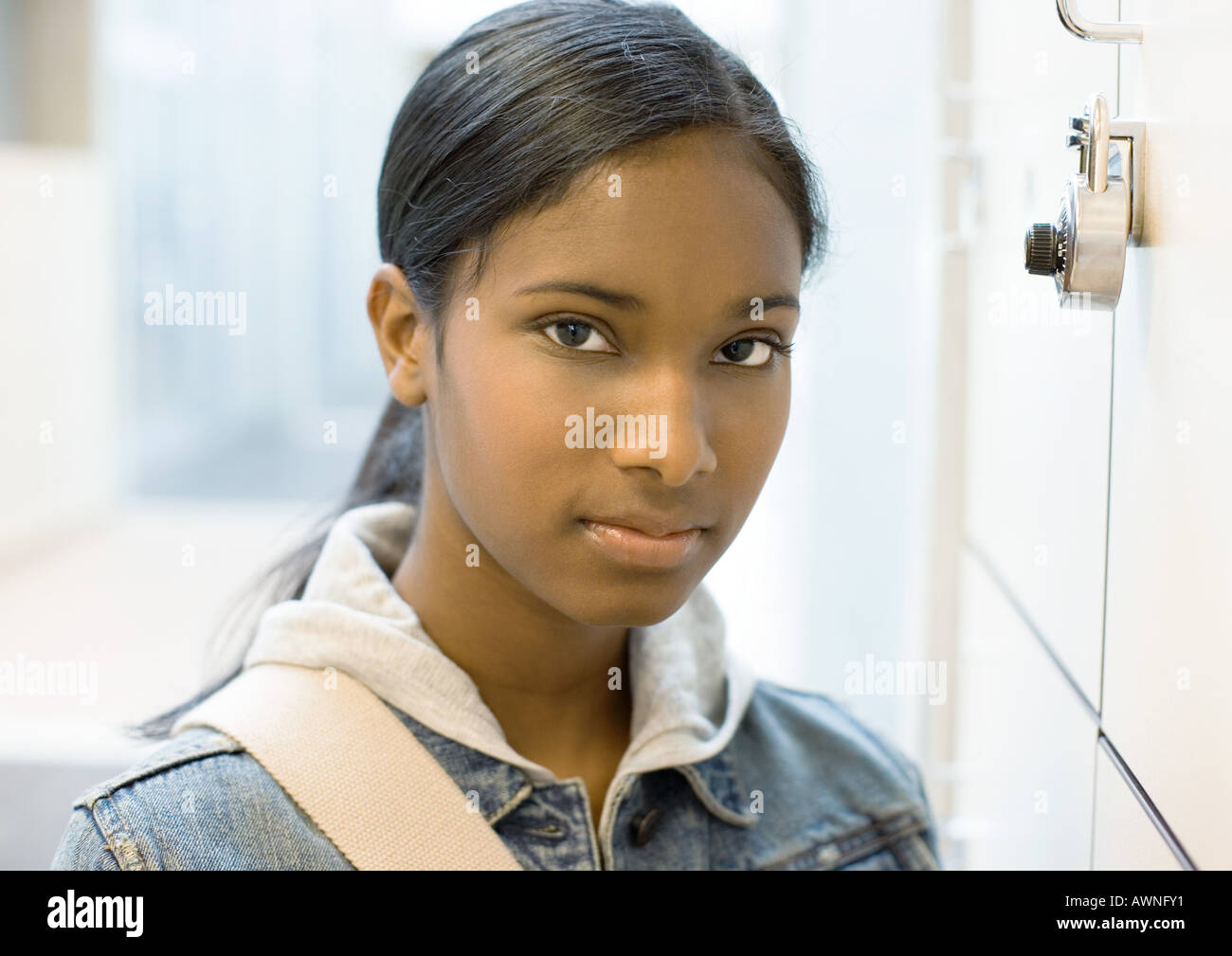 Jovencita de pie junto a la taquilla Foto de stock