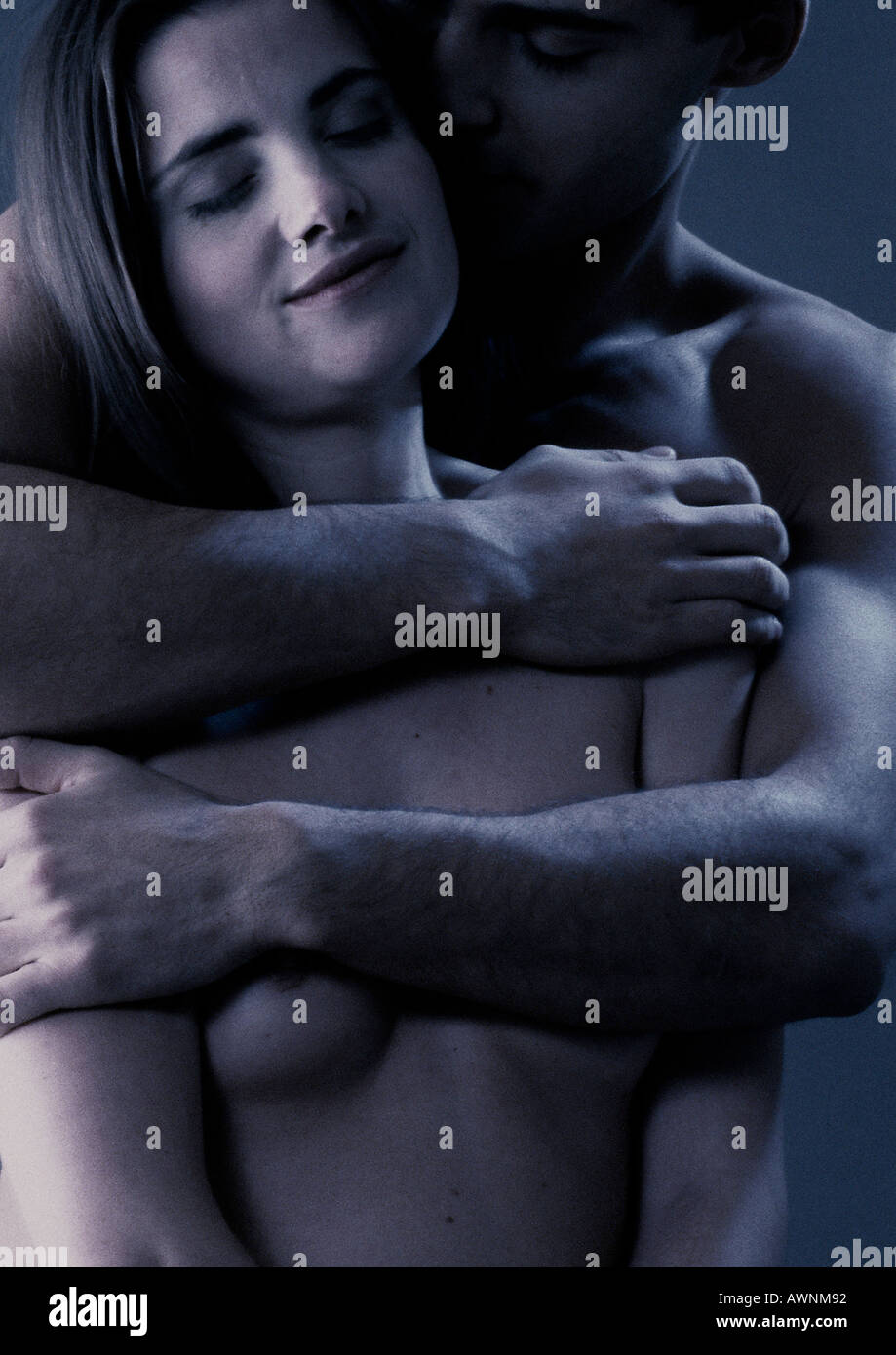 Hombre desnudo abrazando mujer desnuda de espaldas, close-up Fotografía de stock