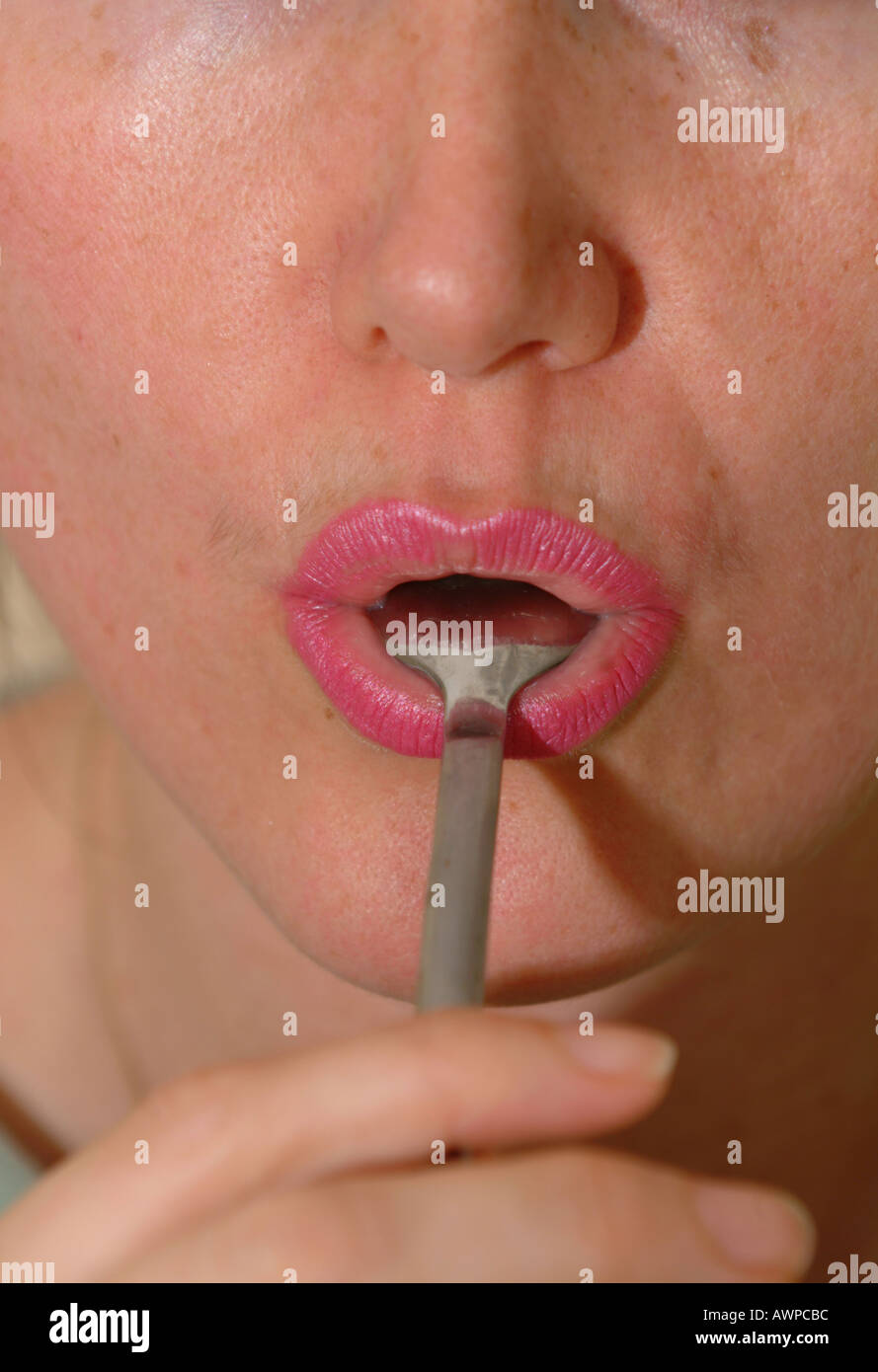 Lenguaje corporal chupar lamer la cuchara boca comer comer consumen  afrontar Fotografía de stock - Alamy