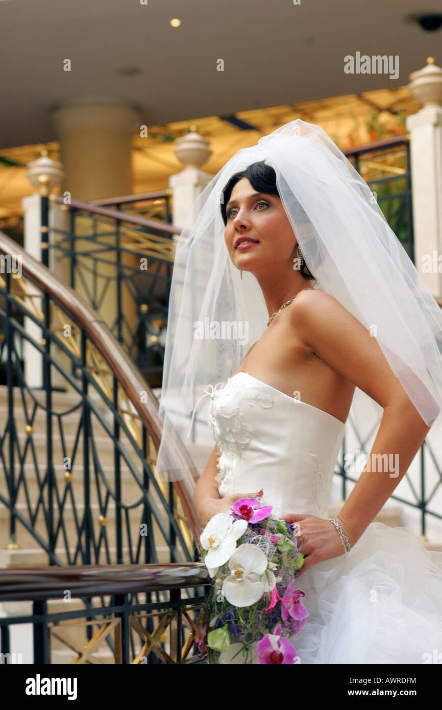 Hermosa novia sonriente en vestido blanco con velo en el día de la boda Foto de stock