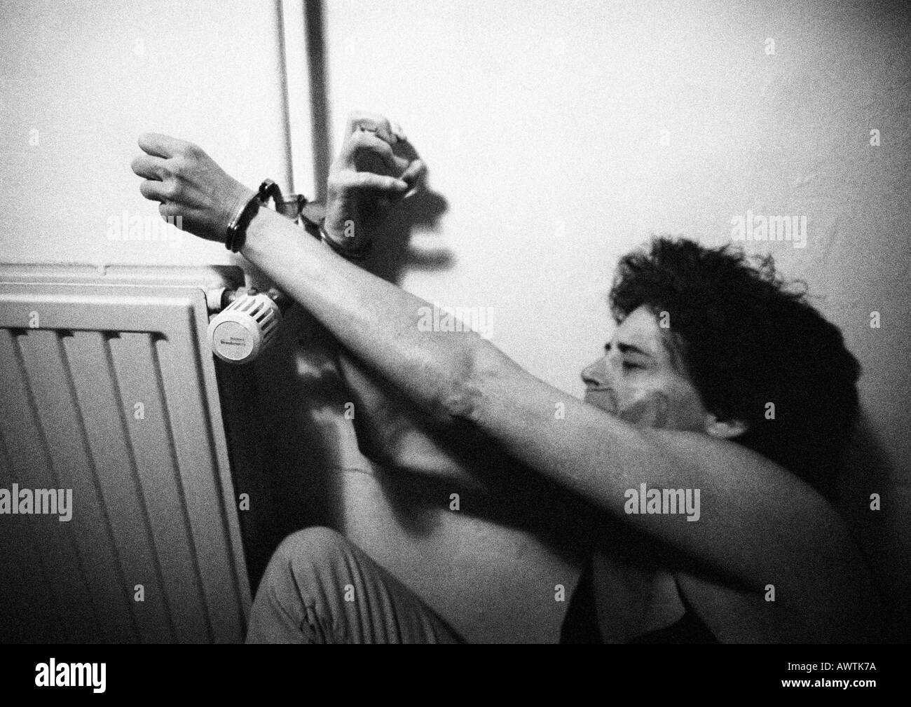 Mujer esposado al radiador, B&W Foto de stock