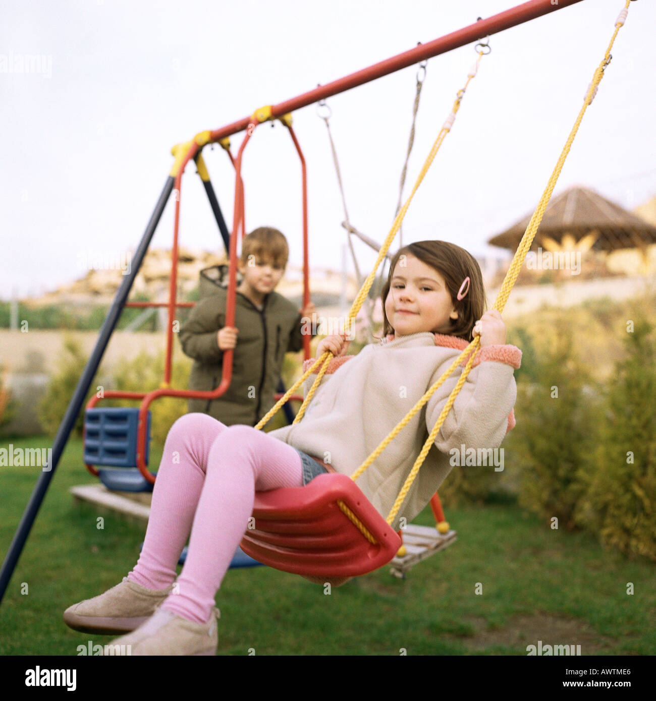 Niños jugando en los columpios Fotografía de stock - Alamy