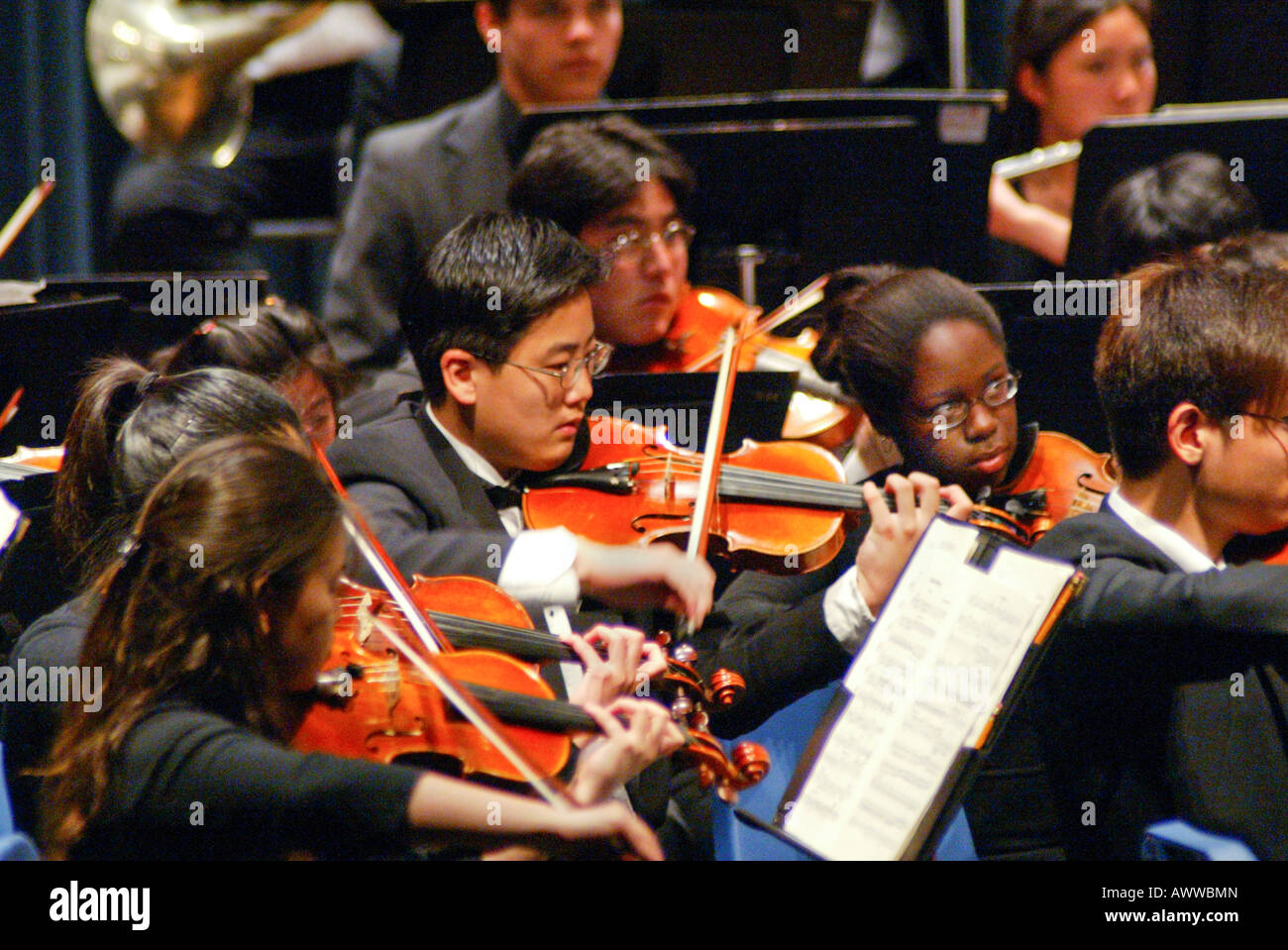 Pluriétnico chicos adolescentes y niñas juegan violines en rendimiento por Pacific Symphony Youth Orchestra Santa Ana, California, EE.UU. Foto de stock