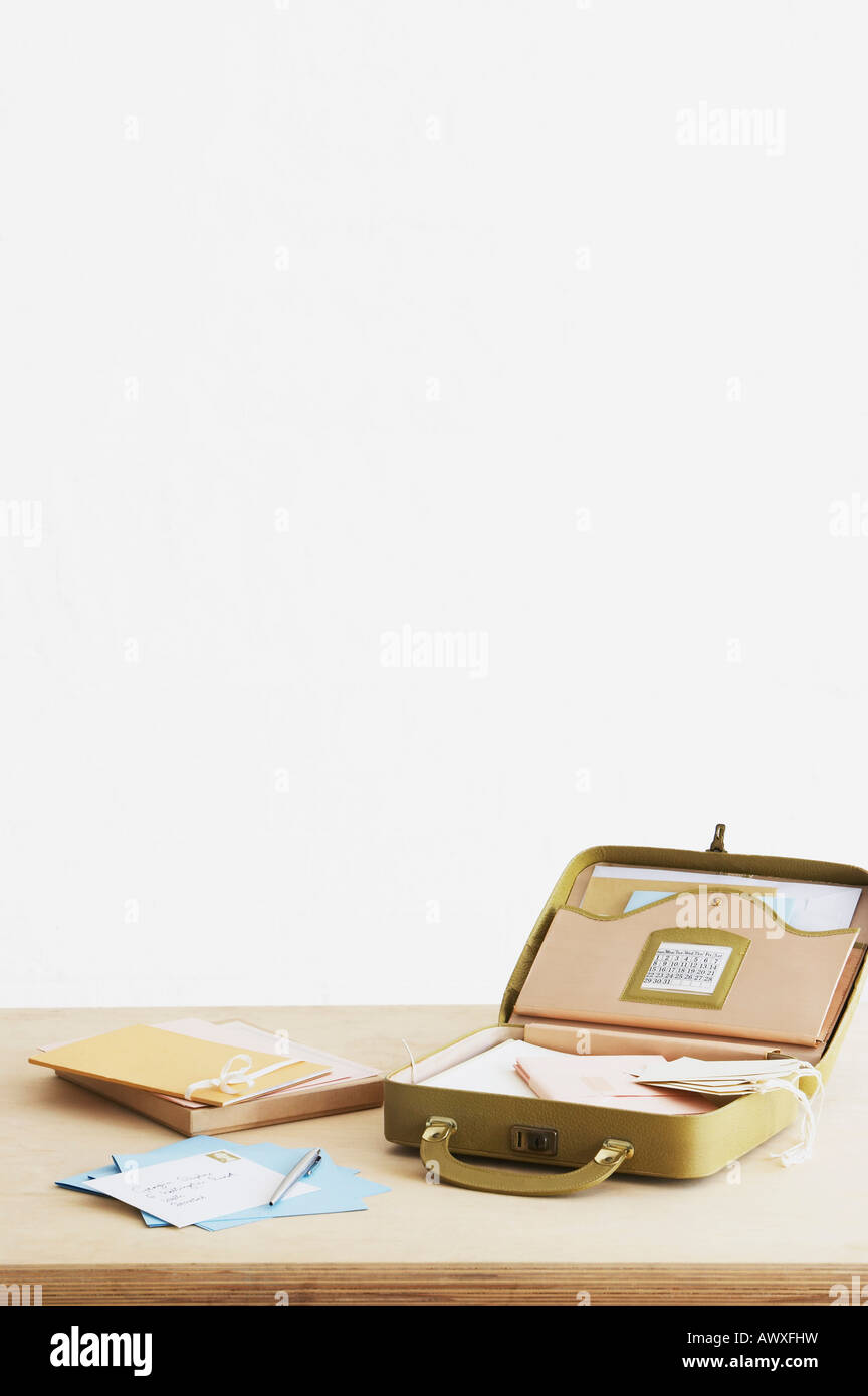 Postales y sobres junto a maleta con artículos de papelería, vista elevada, Foto de estudio Foto de stock