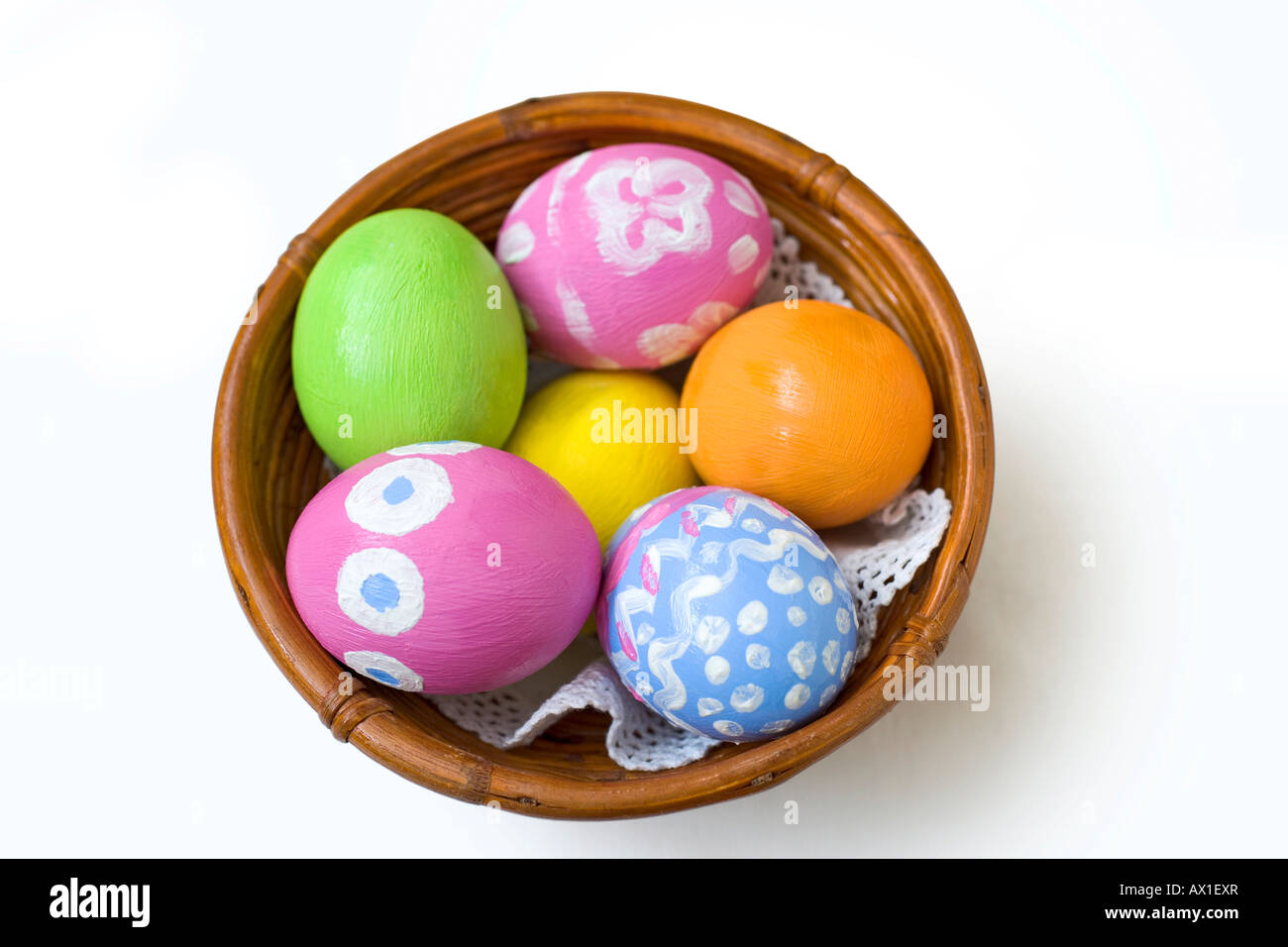 Los huevos de Pascua pintados a mano en un recipiente de bambú marrón Foto de stock