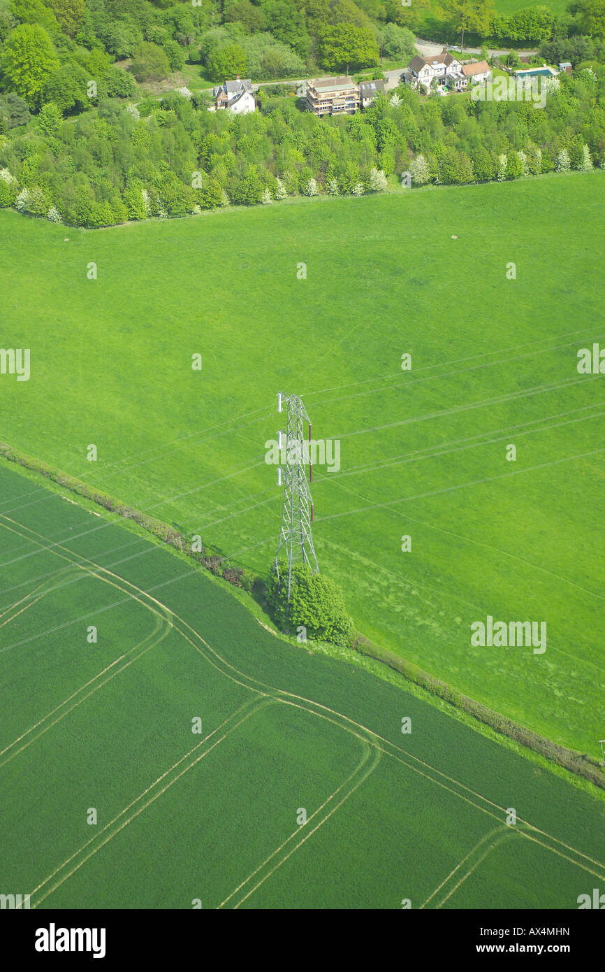 Vista aérea de un poste eléctrico de pie entre dos campos en un entorno rural Foto de stock
