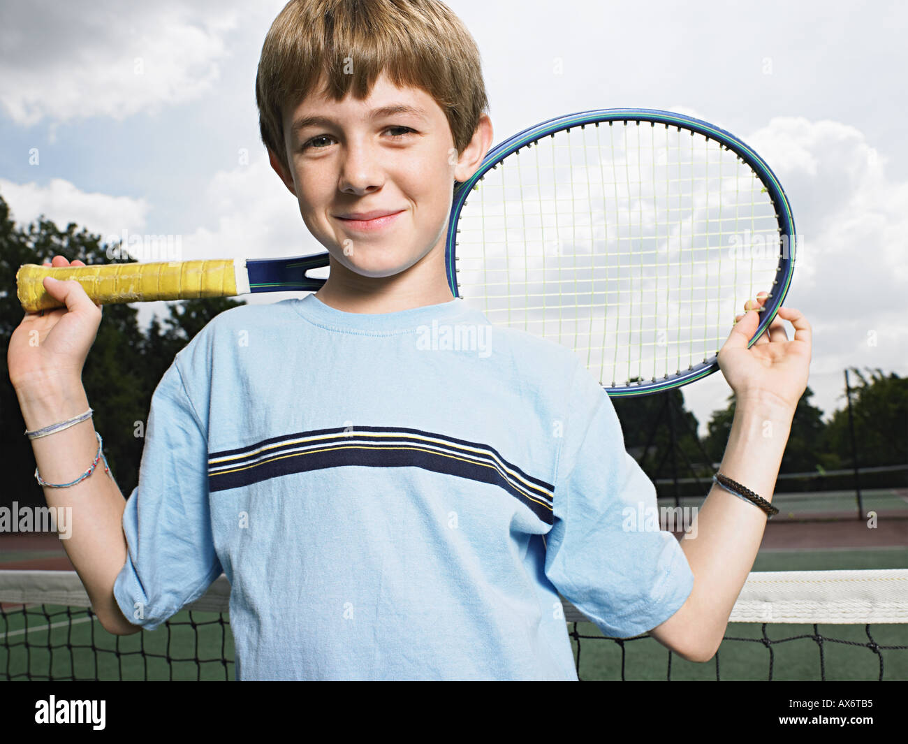 Niño sosteniendo raqueta de tenis Foto de stock